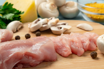 Slicing chicken breast fillet for cooking with champignons and cheese