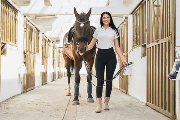 Full length portrait of beautiful woman with sportive horse