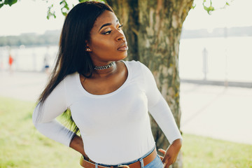 Stylish girl in a summer park. Woman in a blue jeans and white blouse