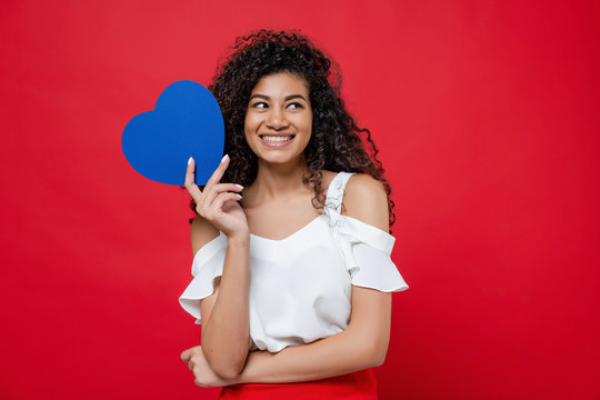 Beautiful Black Woman With Blue Heart Shaped Valentine Card Isolated Over Red