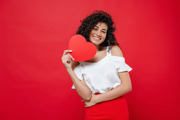 pretty smiling black woman with heart shape valentine card isolated over red