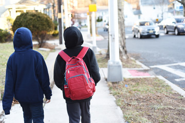 Portrait of the cute african american boy who is going to school with his school  backpack. Student mixed boy on his way to the school. Study for children. Road. Shooting on the july 2018. 