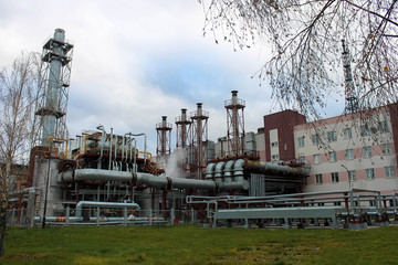 Large building with production equipment with pipes, pumps, compressors and distillation columns at...