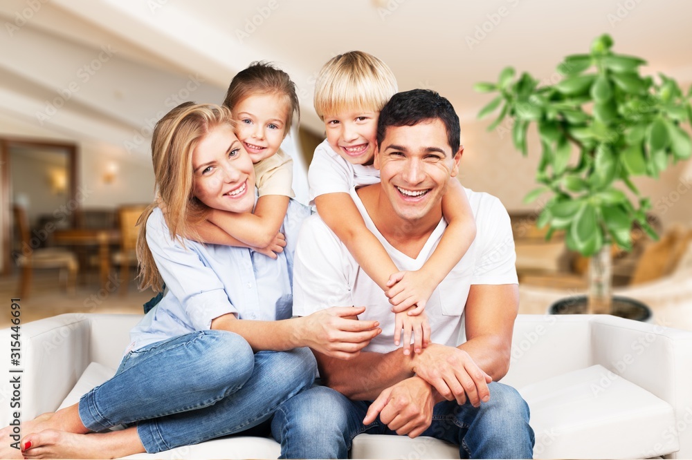 Wall mural Young  family at home smiling at camera