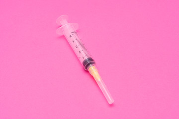 plastic disposable syringe on a pink background. Copy space, macro