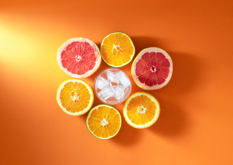 Sliced citrus fruits and glass with ice. Cold drink ingredients