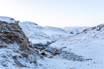 An old bathhouse with a hot spring in the mountains of Iceland. Iceland winter landscape