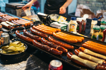 Traditional BBQ barbeque wurst sausages on Christmas market in Germany in Europe in winter. German Night street Xmas and holiday fair in European city.