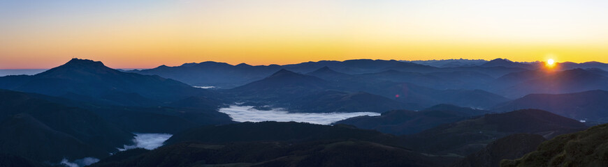 The sun rises with mists over the Pyrenees mountains in Euskadi and Navarra, from the Aiako Harriak Natural Park