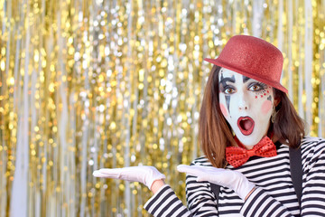 girl dressed in mime with red hat, red bow tie, striped shirt and white gloves.