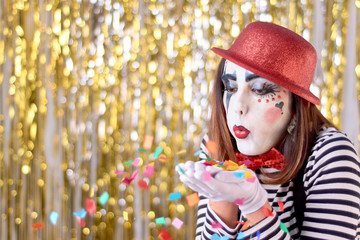 girl dressed in mime with red hat, red bow tie, striped shirt and white gloves.