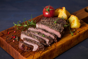 Grilled fillet beef steak with potatoes on serving board