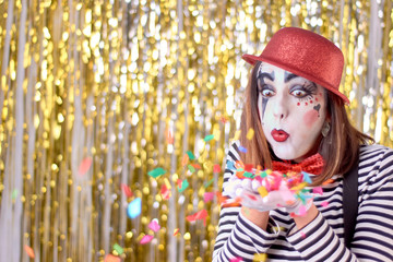 girl dressed in mime with red hat, red bow tie, striped shirt and white gloves.