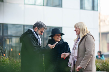 Fototapeta premium leisure, people and friendship concept. Group Of Friends Having Fun Together Outdoors. Three colleagues on break laughing. Friendship is priceless.