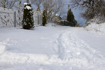 Frosty day in a small village. Human footprints and footprints of machines on the first fresh snow. Wonderful winter wallpapers. Christmas holiday concept. Happy New Year!