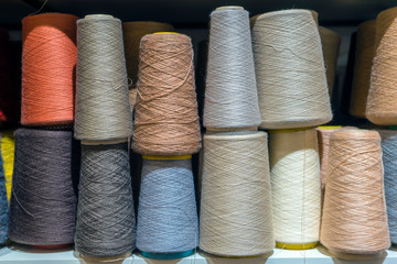 Set of colored threads for sewing on coils. Pile of big colorful spools of thread. Colored thread...