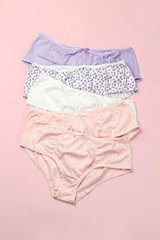 Set of female panties on pink background. Pastel colors fashion flat lay.