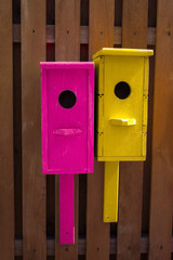 bright vintage wooden birdhouses on a wooden fence