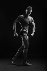 Fototapeta na wymiar Bodybuilder man posing, showing perfect abs, houlders, biceps, triceps, chest