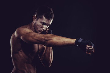 Fototapeta na wymiar MMA Fighter Preparing Bandages For Training. Dark background