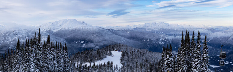 Whistler, British Columbia, Canada. Beautiful Panoramic View of the Canadian Snow Covered Mountain Landscape during a cloudy and colorful winter sunset.