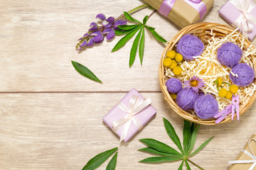 Bouquet on the table. Holiday gift. Wrapped violet presents with ribbon. Straw basket with flowers.