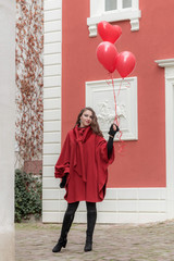 Young woman with heart shaped balloons outdoor.