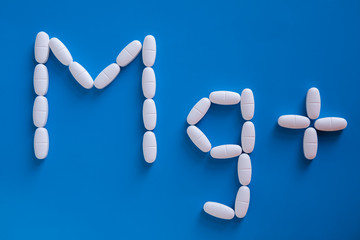 Magnesium symbols from pills on a blue background.