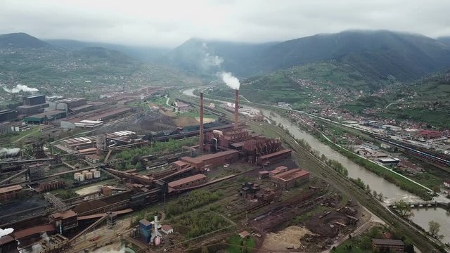 Industrial factory pollution atmosphere, large smoke from chimneys near city, shoot from drone - (4K)