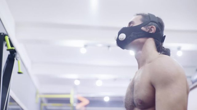 man in a training mask, trains on a bike
