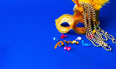 Carnival mask on blue background with silver beads. Mardi Gras concept. Copy space