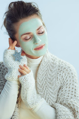 40 years old housewife with green facial mask holding snowflake
