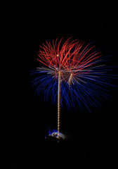 Several colorful fireworks exploding in the dark sky in the middle of the night. The explosions...