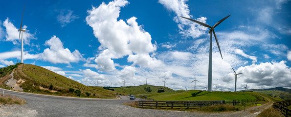Panoramic view of rural farm grazing countryside of hills and valleys with wind turbines on the peaks