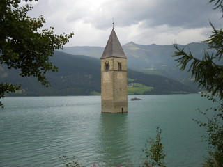 Enjoying the amazing flooded town in the Reschen see lake as curious tourist in Italy
