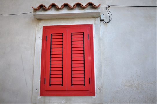 Red closed shutters on mediterranean street