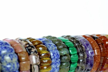 A set of bracelets made from natural stones of different breeds. Handmade products from natural material on a mesh background.
