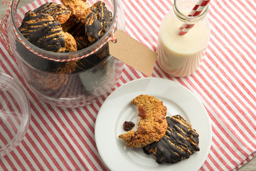 chocolate and raisin oatmeal cookies and a glass cookie jar