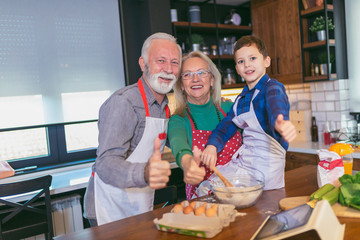 Young boy having fun with her grandparents in the kitchen