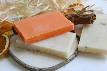 Handmade natural soap on wooden background. Spa natural treatments.Natural soap, handmade organic natural soap with body brush, oil bottle and cotton towel, spa and wellness products.