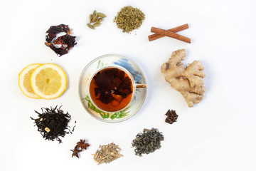A cup with tea surrounded by different types of teas and warming, healing spices 