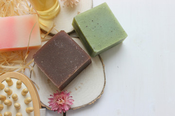 Handmade natural soap on wooden background. Spa natural treatments.Natural soap, handmade organic natural soap with body brush, oil bottle and cotton towel, spa and wellness products.