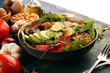 Healthy salad bowl with quinoa, tomatoes, chicken, avocado, lime and mixed greens and mushrooms