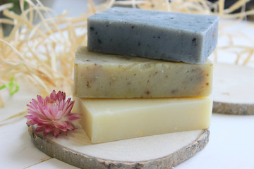 Handmade natural soap on wooden background. Spa natural treatments.Natural soap, handmade organic natural soap with body brush, oil bottle and cotton towel, spa and wellness products.