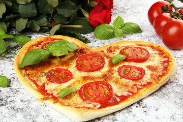 pizza Heart shaped margherita with tomatoes and mozzarella vegetarian. Food concept of romantic love pizza for Valentines Day.
