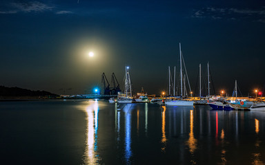 Parked boats under the full moon