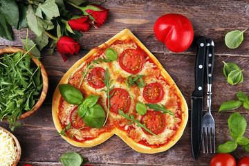 pizza Heart shaped margherita with tomatoes and mozzarella vegetarian. Food concept of romantic love pizza for Valentines Day.