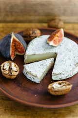 Handmade brie cheese in herbs and figs