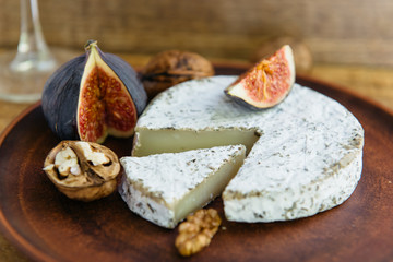 Handmade brie cheese in herbs and figs