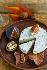 Handmade brie cheese in herbs and figs